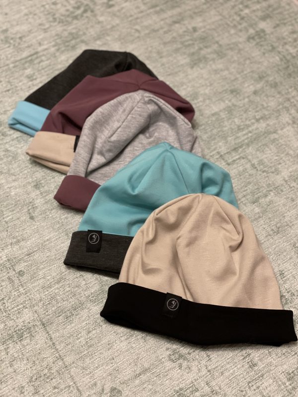 fünf verschiedene Modell der Wendemützen in blau, grau, mauve und beige, die handgemachten Beanies oder Schlappmützen von Fashionista sind fair und in Klagenfurt gefertigt, auch die Stoffe stammen aus nachhaltiger Produktion